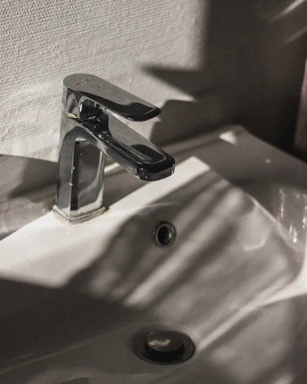 New chrome faucet on a white basin