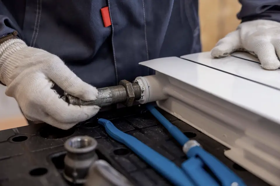 Plumber fitting a supply pipe with a press tool